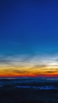 Sunset to night drone hyperlapse in winter landscape with snow and silver clouds, vertical