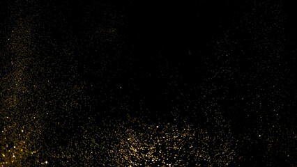 Obraz premium Shimmering gold glitter particles on black background. Luxury golden dust sparkle texture surface.