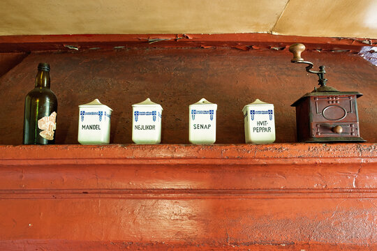 Kitchen shelf with labeled ceramic spice jars and antique coffee grinder