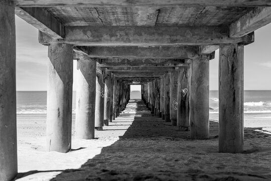 Black and white perspective view of a concrete pier on a sandy beach