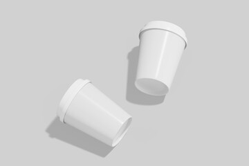 Two white disposable cups with lids, one lying on its side, on a light gray background with subtle shadows