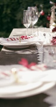 Hands, setting table and outdoor at Christmas for lunch, candy cane or plates with decoration. Person, creativity and cloth for dining, display or presentation for social event at xmas in backyard