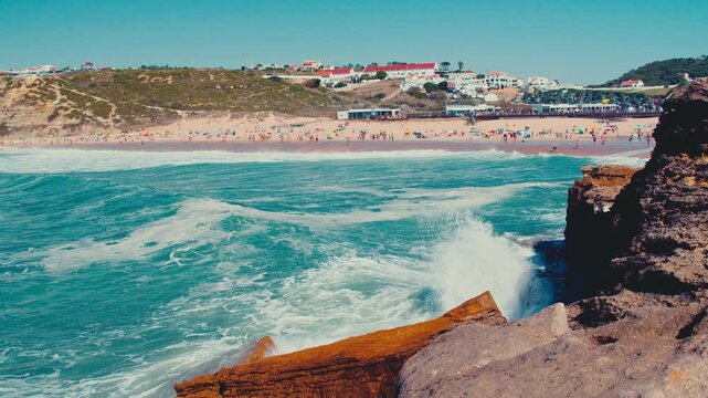 Panoramic view of the beautiful sandy beach on the Atlantic Ocean coast. View to the sea coast on a sunny day with many people on it. Beautiful seascape on summer. Travel and vacation concept