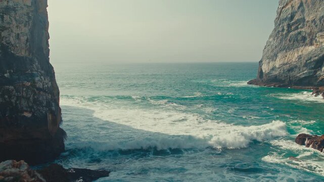 Beautiful nature seascape with azure water and high cliffs on a sunny summer day. Beautiful scenery. Stunning oceanscape featuring azure waters and rocks, blue sky and rolling waves to the shore.