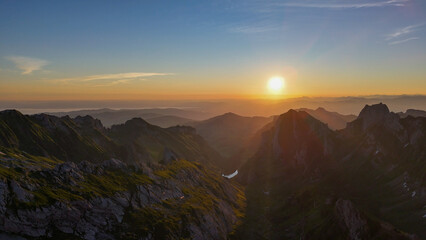 Aerial, bird view, Sunset on Alpstein mountains in Switzerland. Amazing sunset, impressive mountains with rocky peaks and slopes. Wonderful nature, alps of Switzerland. Hiking outdoor travel destinati