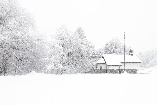 Church in the snow at Cainallo pass near Como lake, Northern Grigna regional park, Lombardy