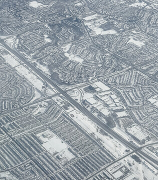 Aerial view snowy houses and roads in city of Toronto on winter day.