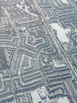 Aerial view snowy houses and roads in city of Toronto on winter day.