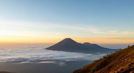 Fototapeta premium Scenic View of a Majestic Mountain Peak Above a Tranquil Sea of Clouds at Golden Dawn.