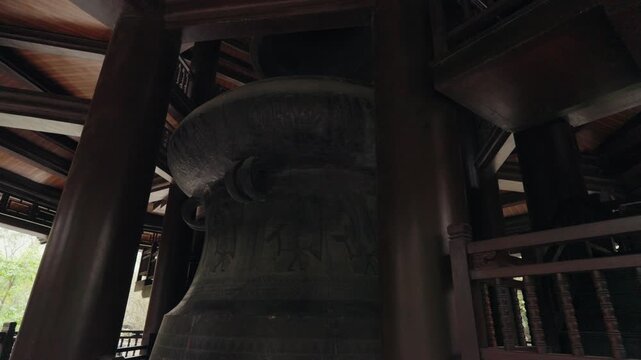 An ancient bronze bell hangs inside Ba Dinh Pagoda Complex in Hanoi, Vietnam, symbolizing Buddhist tradition, spiritual practice, and historic temple architecture.