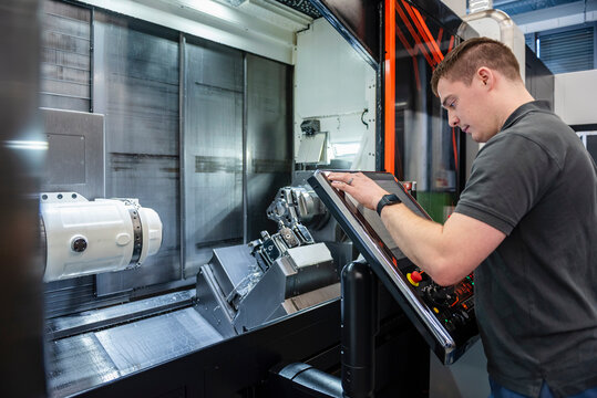 Machine operator programming industrial equipment in factory