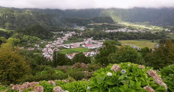 A small town with houses and trees in the background at Furnas, Azores.