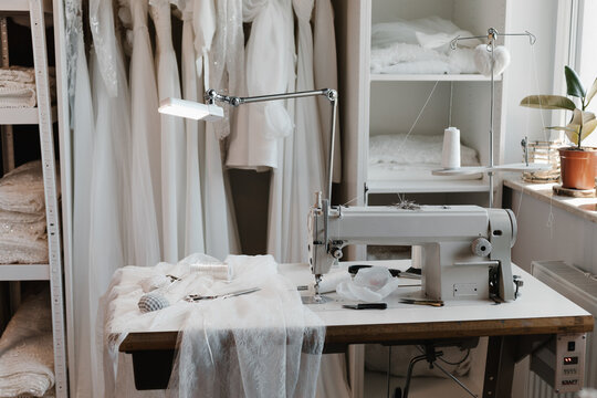 Sewing machine and wedding dress fabric in fashion designer workshop