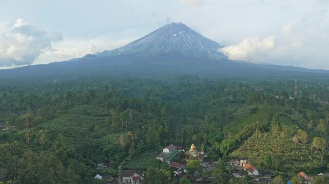Scenic aerial perspective of the majestic semeru volcano, an active stratovolcano, rising above a vast tropical rainforest in east java