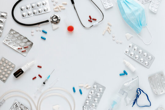 Medical equipment and pills on white background with copy space