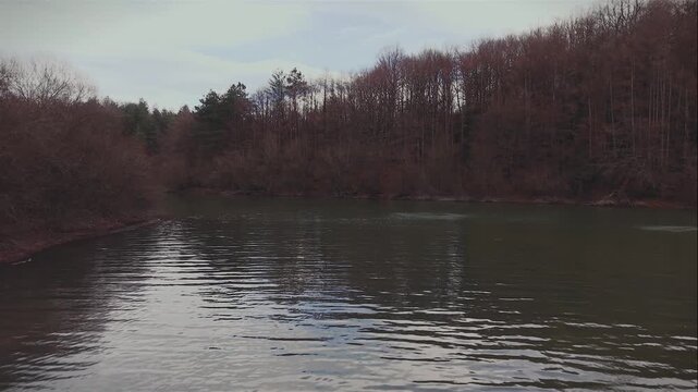 Peaceful glide through a swampy river, lined with beautiful earth toned trees while the late afternoon sun reflects off the gently rippling waters.