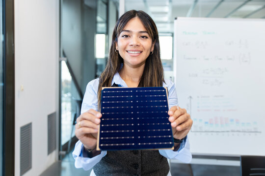 Manager presenting solar panel sample in modern office workspace