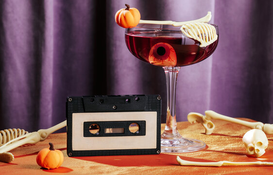 Vintage cassette and Halloween cocktail with skeleton decor on table