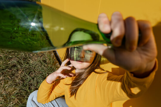 Child with glass bottle outdoors promoting sustainability and recycling