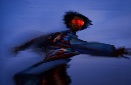 Man in motion with VR set under surreal light in cyberspace