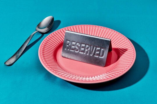 Reserved table with empty plate and spoon highlighting waiting moment