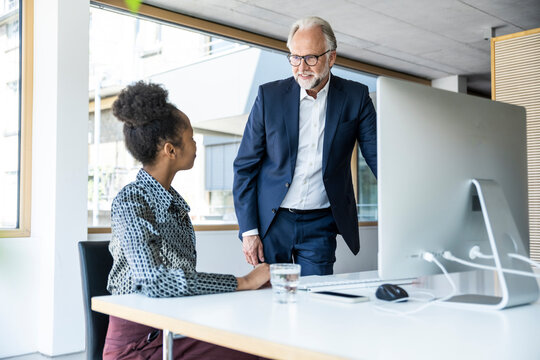Business colleagues in modern office discussing work at desk