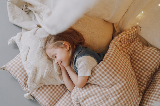 Child resting peacefully in cozy children's room with soft lighting