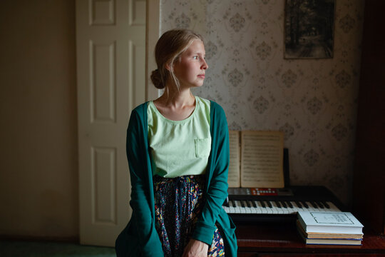 Woman in green cardigan sitting indoors with vintage style at home