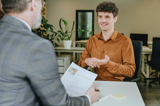 Job interview with candidate and manager discussing resume in office