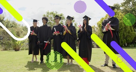 Standing 7 graduates in black gowns and caps on campus lawn, holding diploma scrolls, neon overlays