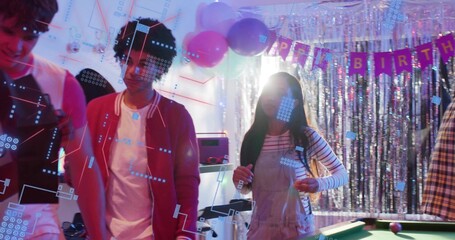 Chatting group wearing red jacket and striped overalls at party, with balloons, pool table