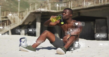 Naklejka premium Drinking shirtless Black man on sand by pier, holding green bottle, kettlebell and social icons