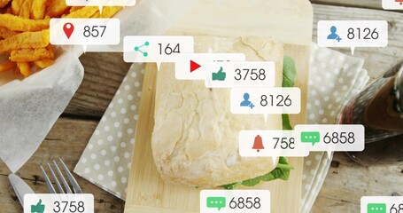 Displaying ciabatta sandwich with lettuce on polka-dot napkin on wooden table, showing social icons