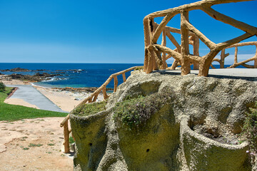 Coastal walkway with rustic textured railings overlooking the Atlantic Ocean and rocky beaches in Foz do Douro, Porto, Portugal. © sebastiangora