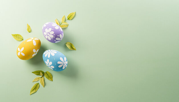 Easter party concept. Top view of easter bunny ears and colorful eggs on pastel background with copyspace for the text.
