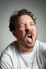 Obraz premium Ecstatic Young Man Screaming with Eyes Closed Expressing Intense Relief or Stress