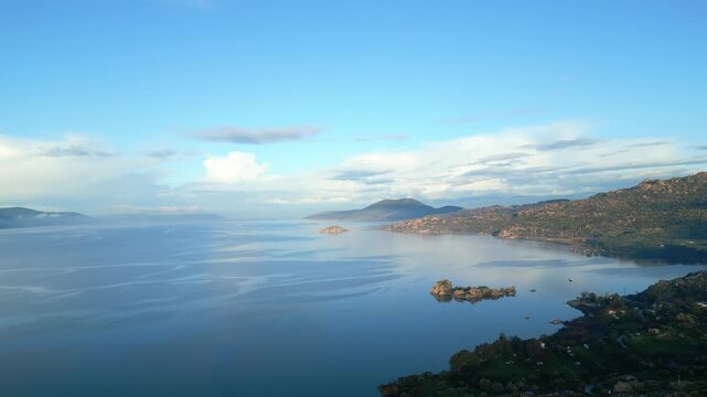 Drone footage captures the stunning natural beauty and historical significance of Bafa Lake Nature Park in Turkey. The aerial perspective showcases the serene waters of Bafa Lake nestled amidst rugged