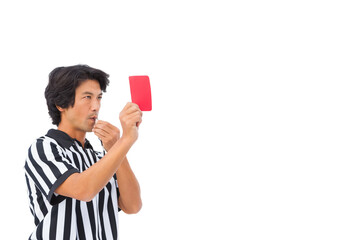 Asian male referee in striped shirt, holding metal whistle, raising red card in studio, copy space © wavebreak3