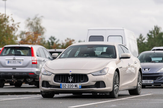 Laxou, France - October 19th 2020 : View on a beige Maserati Ghibli parked on a parking lot with other cars behind.