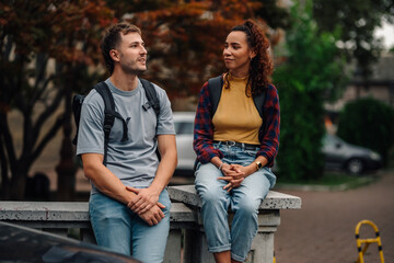 Two students talking and relaxing outdoors between classes