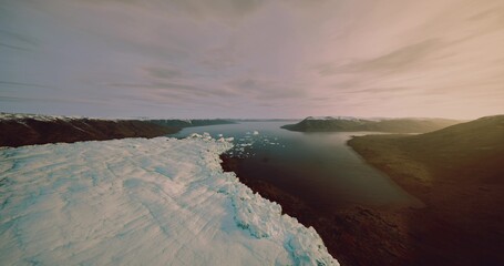 Naklejka premium Icy river landscape with melting shelf, drone survey capturing eroding ice edge under golden dusk, calm water reflecting pastel sky, remote tundra shore