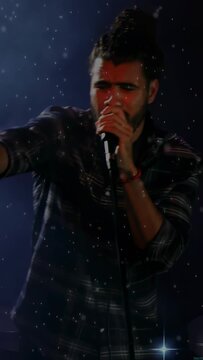 Vertical video: Camera panning, singer at mic, pointing and singing to engage music fans with stars