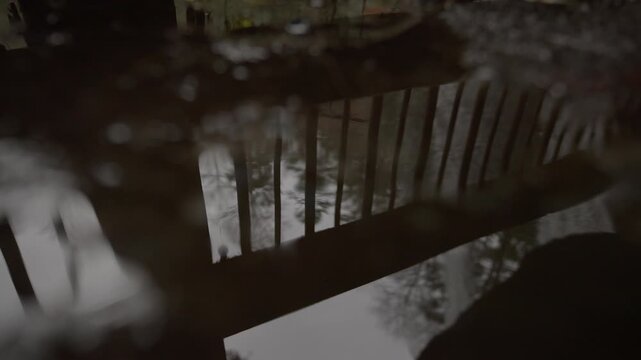 Abstract Reflection of Trees and Light in Water Beneath a Wooden Bridge