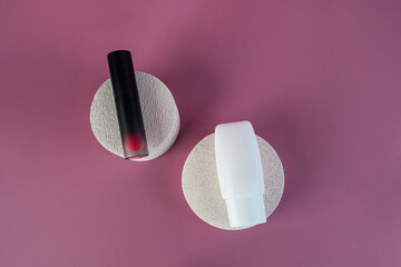 Cosmetic product in tube, bottle, lotion or serum with stylish props on pink background. 
