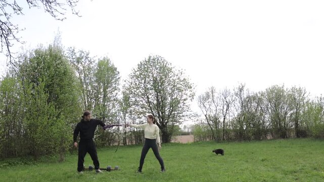 A couple doing a sports warm-up outdoors in the summer