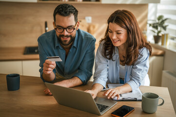 Young couple managing household finances and online shopping together