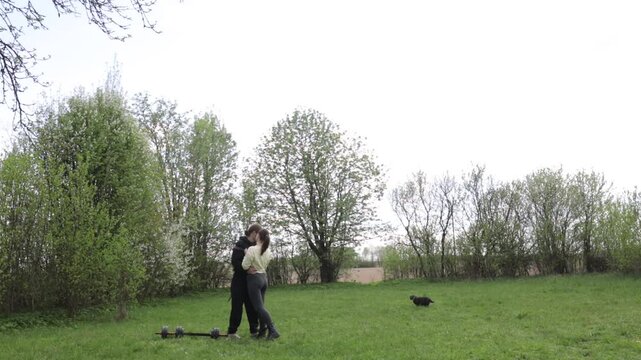 A couple doing a sports warm-up outdoors in the summer