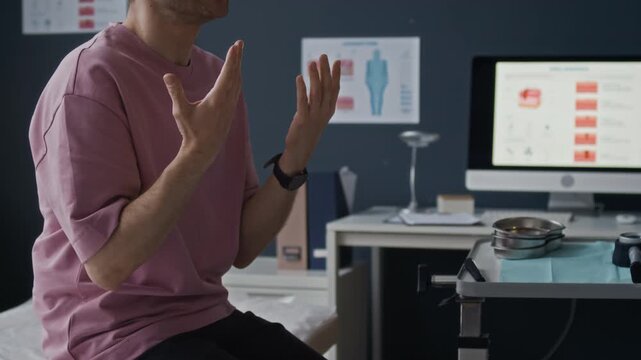 Indoor b roll shot of dermatologist examining male patient during skin consultation, patient touching neck while discussing symptoms in medical office interior with natural light
