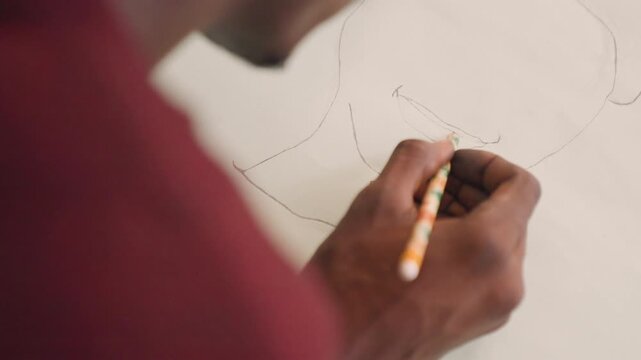 Apprentice meticulously tracing sketches. Close view of ink hand drawing in classroom with sunlight. Detailed depiction of mural apprentice gently outlining guide lines with precision