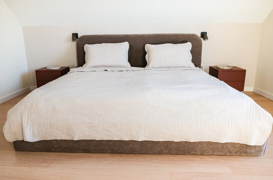 Modern Double Bed with White Linens in a Minimalist Attic Bedroom.